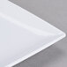A close up of a white Thunder Group square melamine plate with a thin edge.