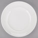 An Arcoroc white porcelain service plate with a circular edge.