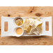 A white rectangular porcelain platter with handles holding a plate of chips and a bowl of sauce.