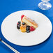 A 10 Strawberry Street Whittier white porcelain plate with dessert and berries and a fork.