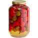 A jar filled with red and yellow whole cherry peppers.