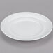 An Arcoroc white porcelain brunch plate with a white rim on a white background.