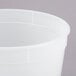 A close-up of a white plastic round deli container with a lid.