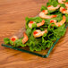 A rectangular glass platter with shrimp and lettuce on it.