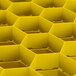 A yellow rectangular Vollrath Traex glass rack with a honeycomb structure.