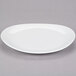 A white 10 Strawberry Street Royal oval porcelain plate on a gray surface.