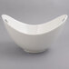 A white porcelain bowl with a curved edge and cut outs.