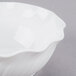 A white plastic swirl bowl on a gray surface.