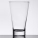A clear Arcoroc highball glass with a black rim on a table.