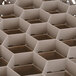 A white Vollrath Traex rack with hexagonal compartments.