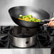 A Town stainless steel wok ring on a stove with a wok full of broccoli.