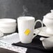 A 10 Strawberry Street white porcelain barrel mug with a yellow tea bag in it.