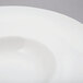 A close-up of a 10 Strawberry Street Whittier white porcelain wide rim bowl.