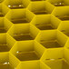 A yellow plastic honeycomb structure with square holes.