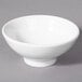 A 10 Strawberry Street Whittier white porcelain footed rice bowl on a gray surface.