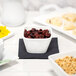 A white table set with 10 Strawberry Street Whittier white square porcelain bowls filled with cereal, nuts, and dried fruit.