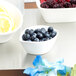 A group of 10 Strawberry Street white porcelain leaf bowls filled with blueberries and lemons.