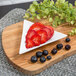 A Whittier white porcelain triangle tid bit tray with strawberries and blueberries on it.