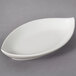 A white oval shaped porcelain tid bit tray.
