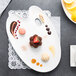 A white porcelain platter with a variety of desserts on it.