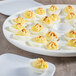 A white porcelain platter with deviled eggs on it.