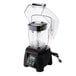 A black Waring commercial blender with a clear container and lid on a counter.