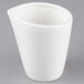 A 10 Strawberry Street Whittier white porcelain milk cup with a small handle on a gray surface.
