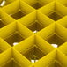 A yellow plastic grid with 36 square compartments.
