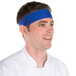 A man wearing a royal blue Headsweats headband in a professional kitchen.