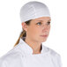 A woman wearing a white Headsweats chef cap.