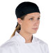 A woman wearing a black Headsweats Shorty Chef Cap.