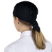 A woman wearing a black Headsweats chef cap.