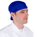 A man wearing a royal blue Headsweats chef cap.