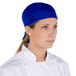 A woman wearing a royal blue Headsweats chef cap.