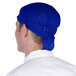 A man wearing a royal blue Headsweats chef cap.