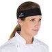 A woman in a chef's uniform wearing a black Headsweats headband.