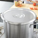 A Vollrath stainless steel pot cover on a large pot.