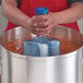 A person using a San Jamar Rapi-Kool cooling paddle to cool liquid in a large pot.