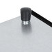 A black knob on a metal surface.