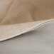 A close up of a cream and gray fabric with a white thread.