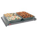 A Hatco Glo-Ray heated shelf with trays of food on a table.