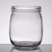 A clear glass American Metalcraft condiment mason jar with a lid on a table.