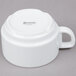 An Arcoroc white porcelain stackable cup with a handle.