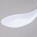 A white Thunder Group Chinese wonton soup spoon.