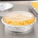 A close-up of macaroni and cheese in a Choice plastic dome lid on a counter.