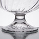 A close up of an Arcoroc clear glass dessert dish with a crystal base.