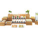 A buffet table with various types of food displayed on a Cal-Mil bamboo rectangular riser shelf.