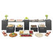 A Cal-Mil Midnight Bamboo rectangular riser shelf on a table with different food items.