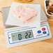 A Cardinal Detecto PS-7 digital portion scale with sliced meat on it.