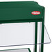 A green glass shelf with clear and green Hatco Buffet Warmers on a table.